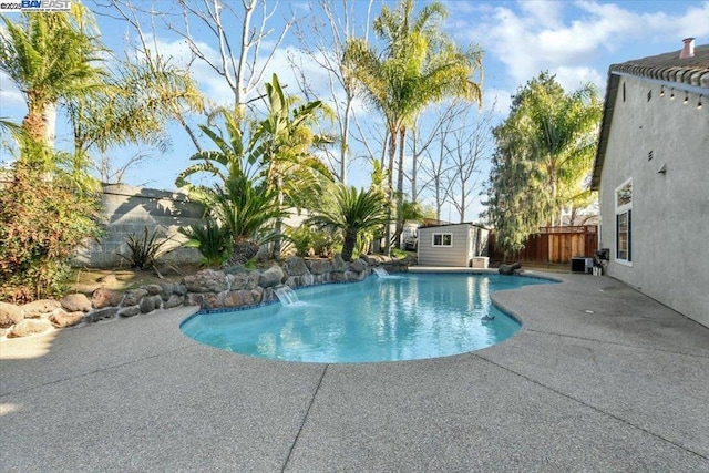 view of pool featuring a shed, cooling unit, a patio area, and pool water feature