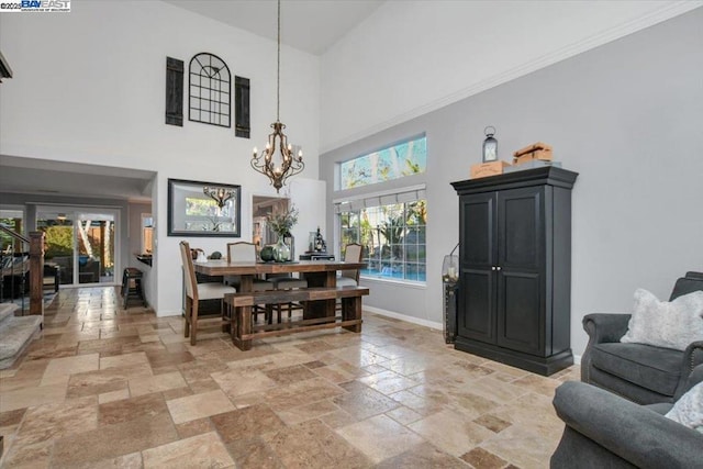 dining area featuring a towering ceiling and a chandelier