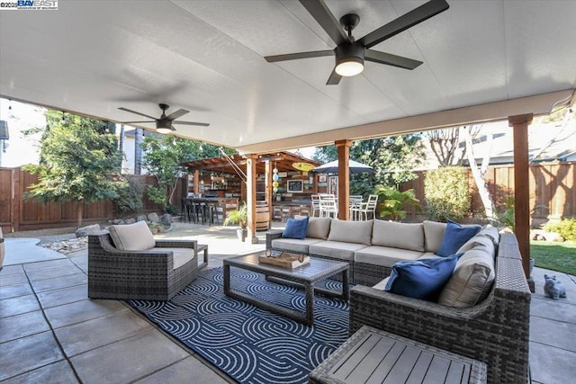 view of patio featuring an outdoor living space, ceiling fan, and a bar