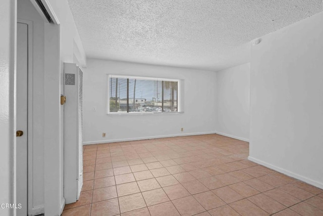 tiled spare room featuring a textured ceiling