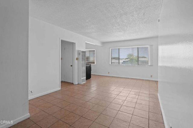 unfurnished living room featuring light tile patterned flooring and a textured ceiling