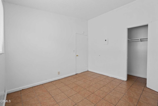 unfurnished bedroom featuring a closet and light tile patterned floors