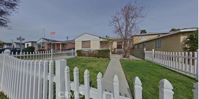 view of front facade featuring a fenced front yard and a front lawn