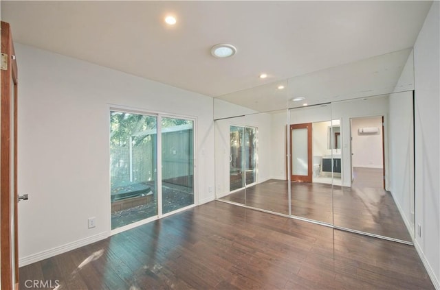 unfurnished bedroom with dark hardwood / wood-style flooring, access to outside, and ensuite bathroom