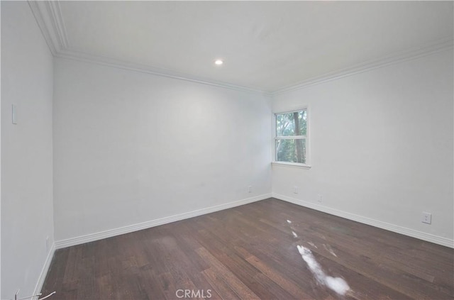 spare room featuring ornamental molding and dark hardwood / wood-style floors