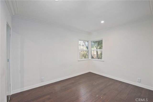 spare room featuring crown molding and dark hardwood / wood-style floors