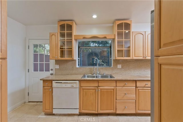 kitchen with white dishwasher, light tile patterned floors, backsplash, and sink