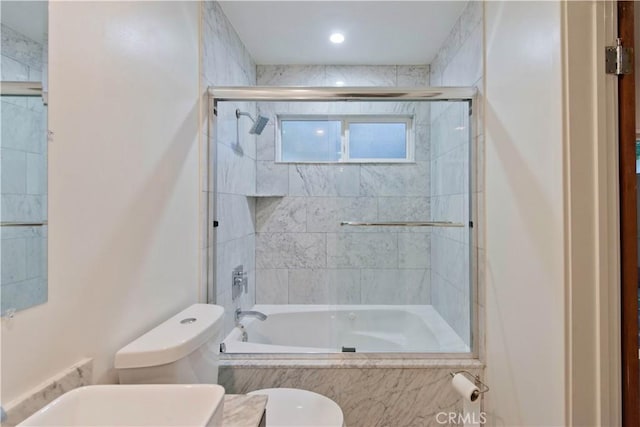 bathroom featuring toilet and combined bath / shower with glass door