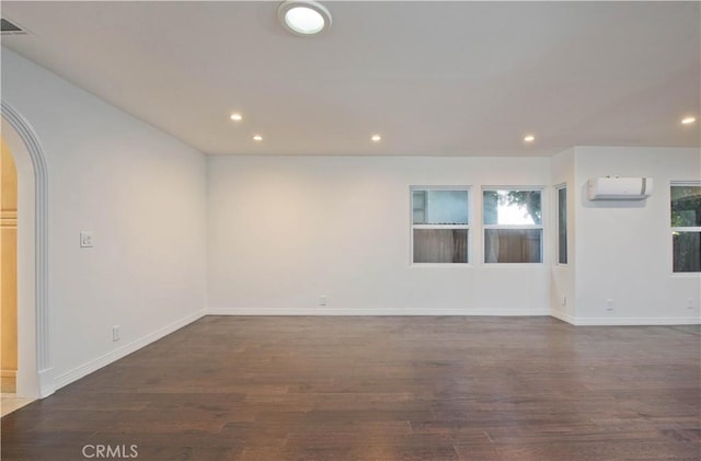 unfurnished room with dark wood-type flooring and a wall mounted AC