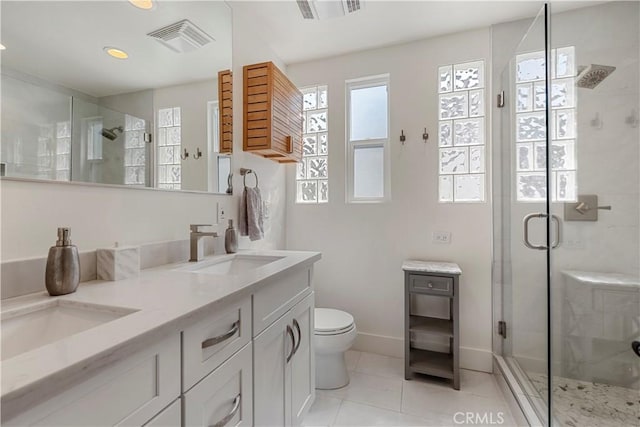 bathroom with vanity, toilet, a shower with shower door, and tile patterned flooring