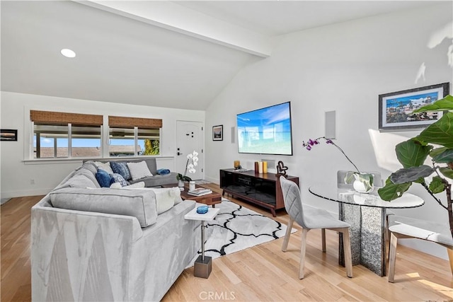 living room featuring light hardwood / wood-style flooring and vaulted ceiling with beams