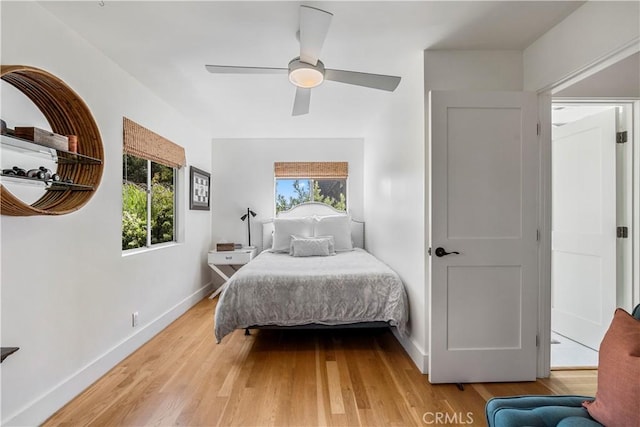 bedroom featuring multiple windows, hardwood / wood-style floors, and ceiling fan