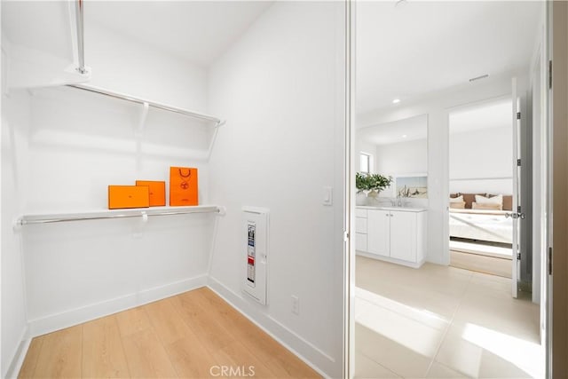 walk in closet featuring sink and light wood-type flooring