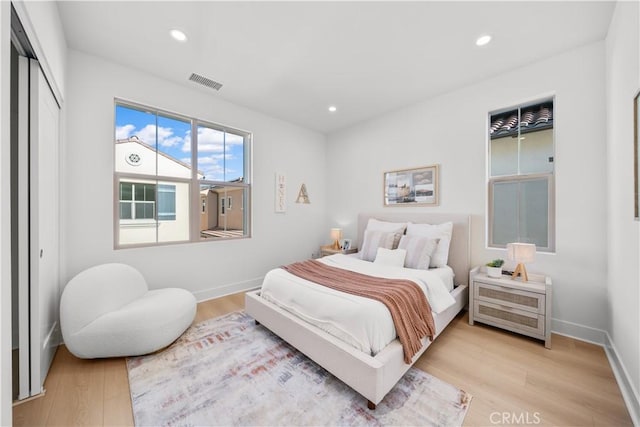 bedroom with light wood-type flooring and a closet