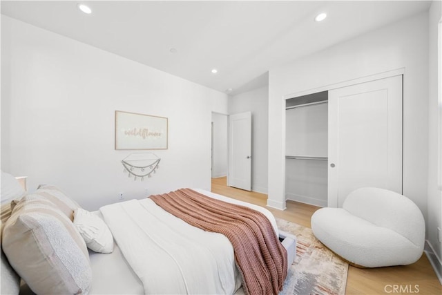 bedroom with a closet and light hardwood / wood-style floors