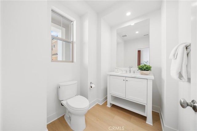 bathroom featuring toilet, wood-type flooring, and vanity