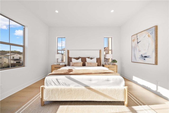 bedroom featuring multiple windows and light wood-type flooring