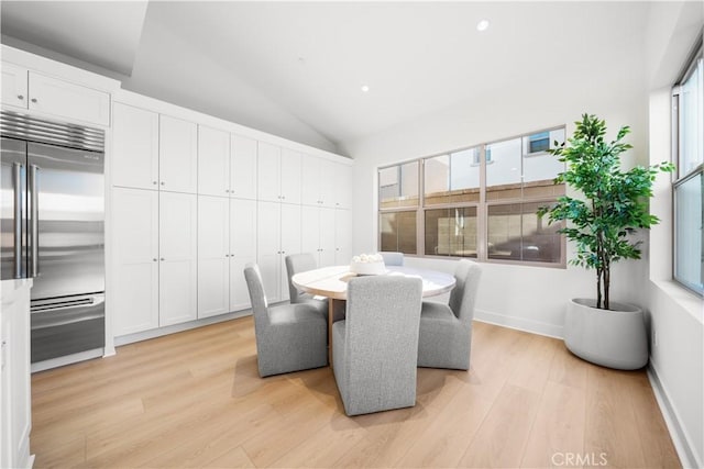 dining area featuring high vaulted ceiling, light hardwood / wood-style floors, and a wealth of natural light