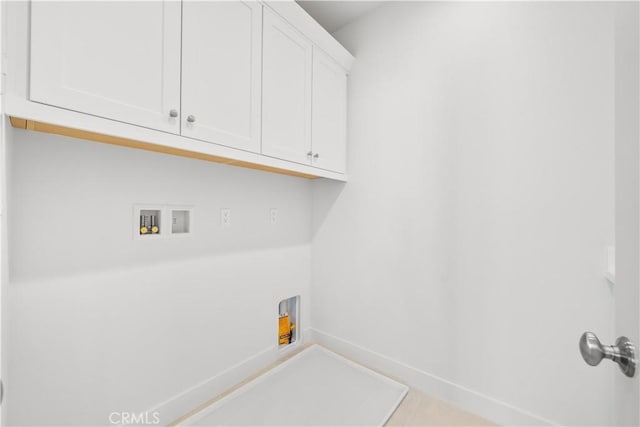 laundry room with washer hookup and cabinets