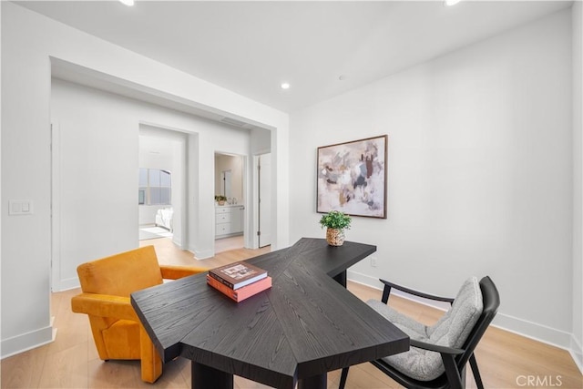 home office with light hardwood / wood-style flooring