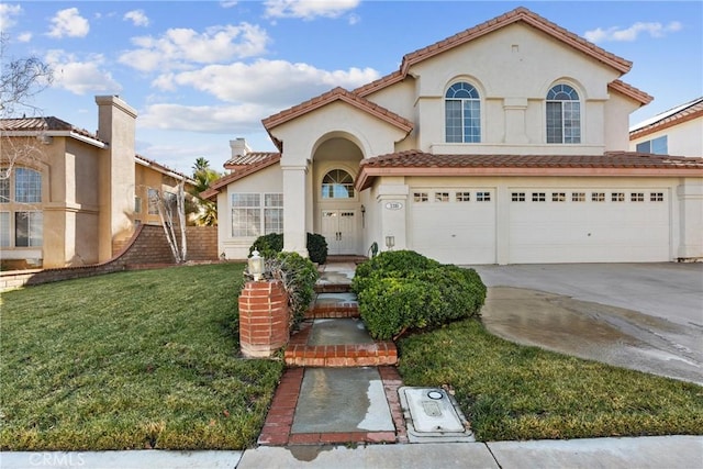 mediterranean / spanish-style home with a front yard and a garage