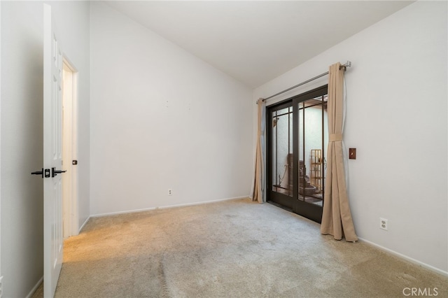 carpeted spare room with lofted ceiling