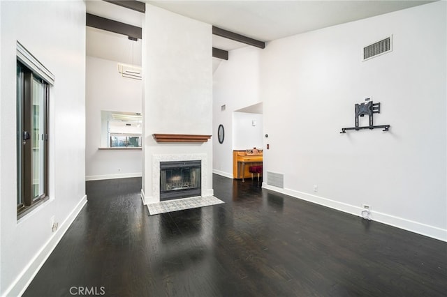 unfurnished living room featuring dark hardwood / wood-style flooring and beamed ceiling