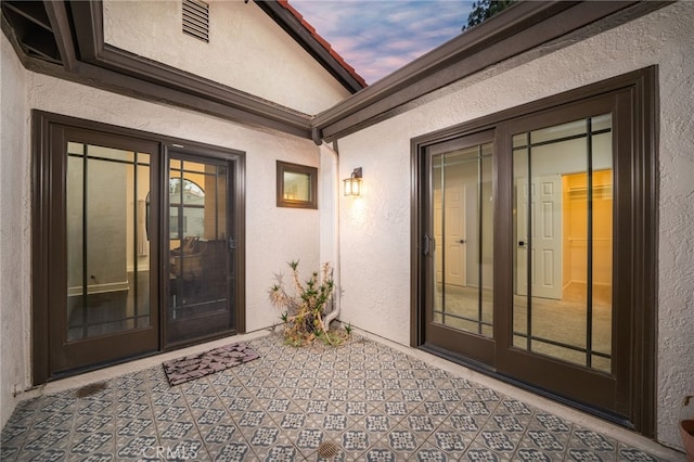 exterior entry at dusk with a patio area