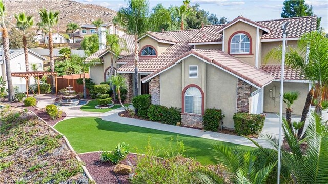 mediterranean / spanish-style house featuring a front yard