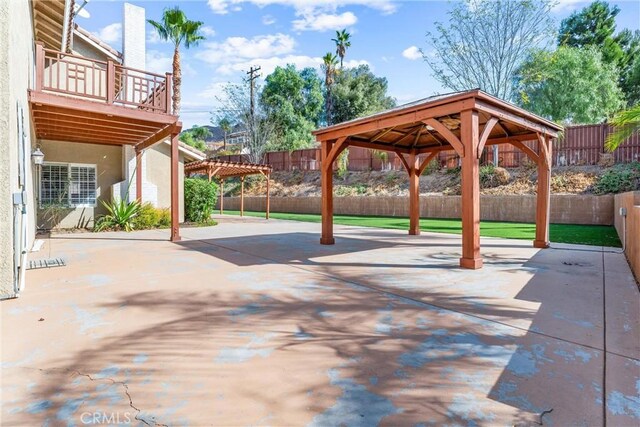 view of patio with a gazebo and a balcony