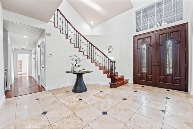 tiled foyer entrance with a high ceiling