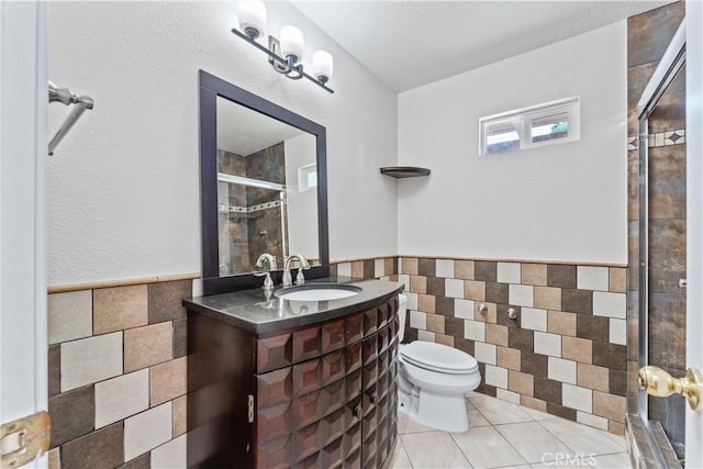 bathroom featuring tile walls, tile patterned flooring, vanity, an enclosed shower, and toilet