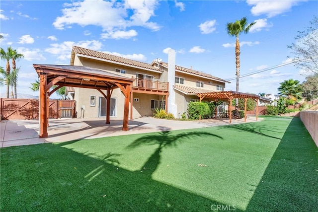 rear view of house featuring a pergola, a patio area, and a lawn