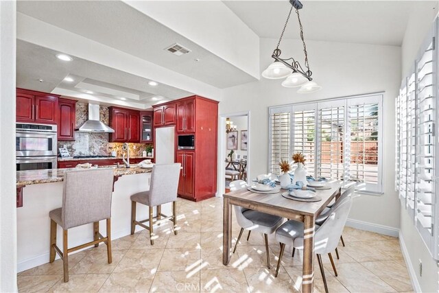 tiled dining space with a raised ceiling