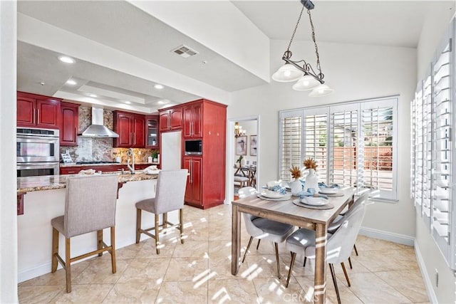 dining space with light tile patterned floors and a tray ceiling