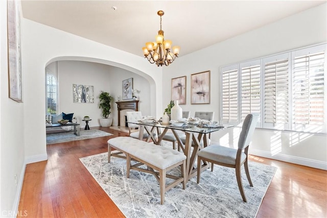 dining area with hardwood / wood-style floors and a notable chandelier