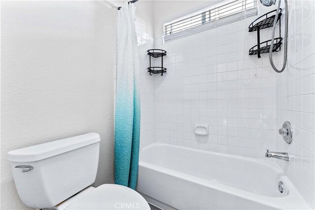 bathroom with shower / bath combo and toilet