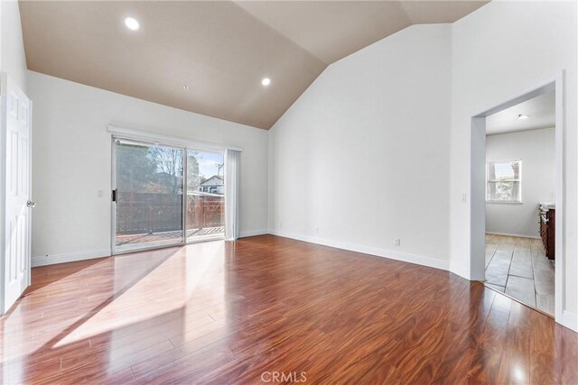 empty room featuring hardwood / wood-style floors and high vaulted ceiling