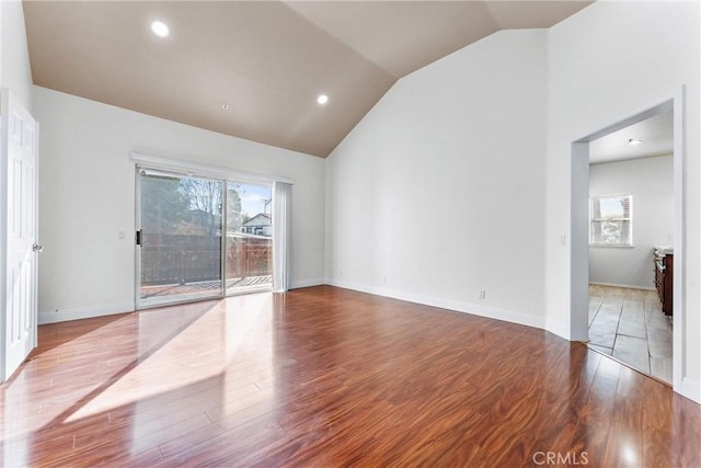 empty room featuring high vaulted ceiling and wood-type flooring