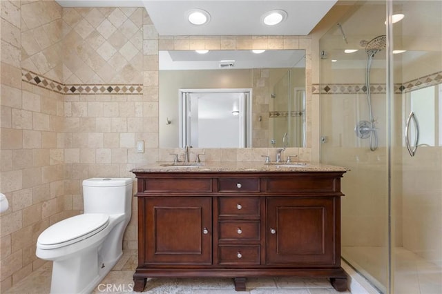 bathroom featuring tile walls, an enclosed shower, vanity, tile patterned floors, and toilet