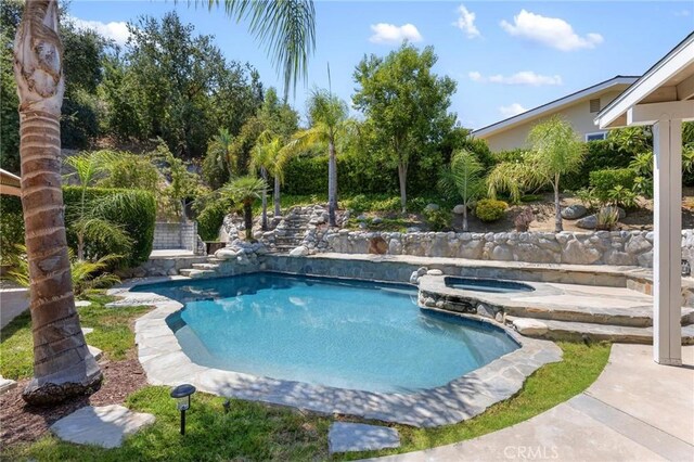 view of swimming pool with an in ground hot tub