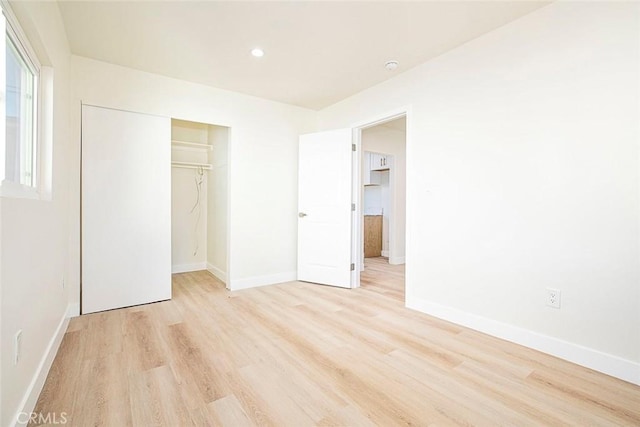 unfurnished bedroom with light hardwood / wood-style floors and a closet