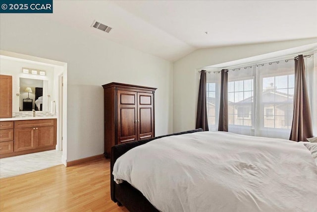 bedroom with sink, lofted ceiling, light hardwood / wood-style floors, and ensuite bath