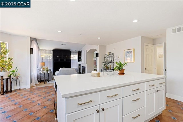 kitchen with a wealth of natural light, white cabinets, a breakfast bar, and a center island