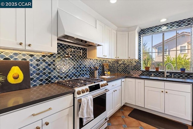 kitchen with sink, white cabinets, white range with gas cooktop, and premium range hood