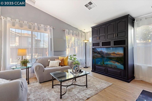 living area featuring light wood-type flooring and vaulted ceiling