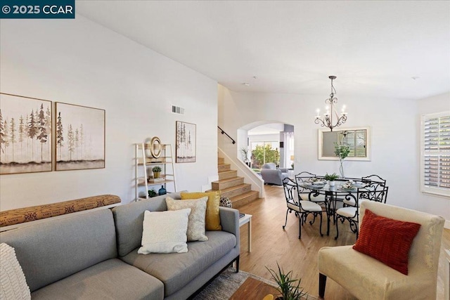 living room featuring light wood-type flooring and a notable chandelier