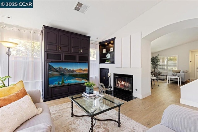 living room featuring light wood-type flooring and vaulted ceiling