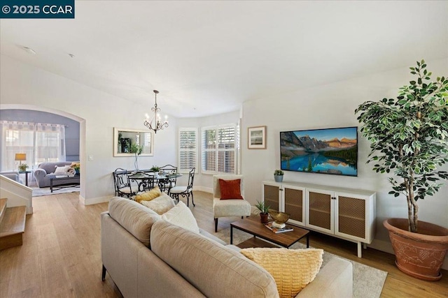 living room with an inviting chandelier and light wood-type flooring