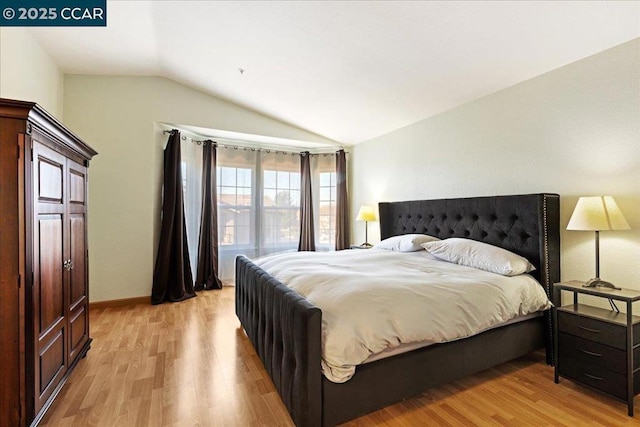 bedroom featuring vaulted ceiling and light hardwood / wood-style floors